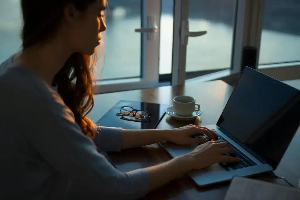 Woman writing a grant by herself on a laptop.