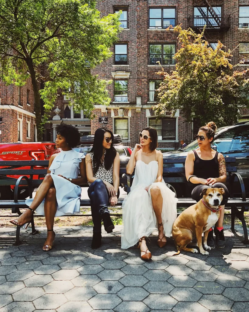 Join our Social Impact Level Up Collective for entrepreneurs who want to make social change a reality. Women on a bench chatting in community with a dog.